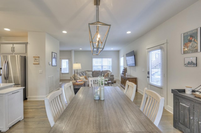 dining area featuring hardwood / wood-style floors and a notable chandelier