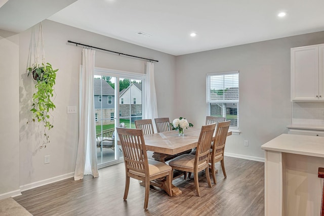 dining area featuring dark wood-type flooring and a healthy amount of sunlight