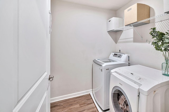 washroom with dark hardwood / wood-style flooring and washer and clothes dryer