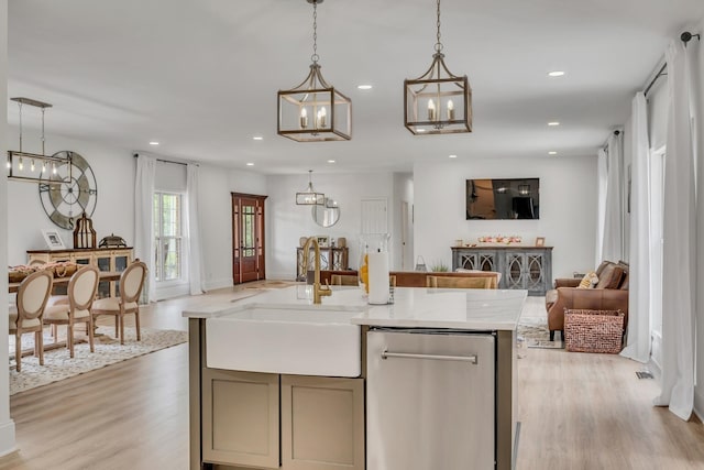 kitchen with dishwasher, sink, an island with sink, and decorative light fixtures