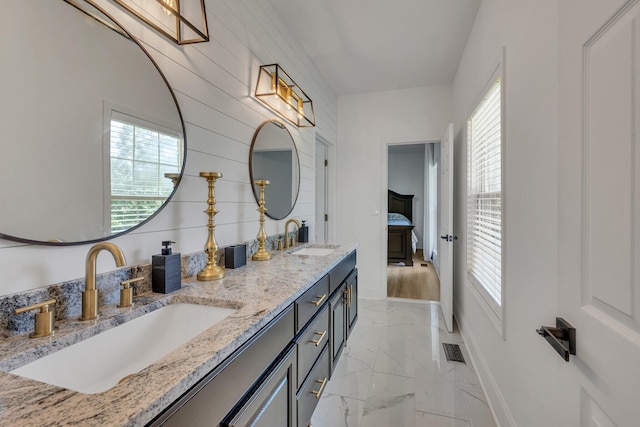 bathroom with vanity, plenty of natural light, and wooden walls