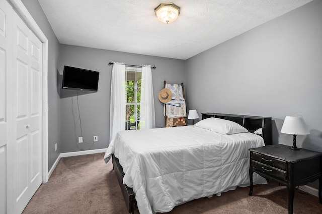 carpeted bedroom with a textured ceiling and a closet