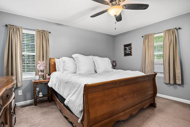 carpeted bedroom with multiple windows and ceiling fan