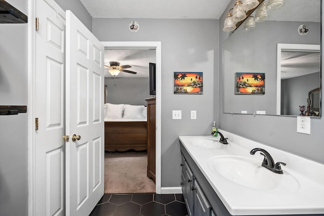 bathroom with tile patterned floors, ceiling fan, vanity, and a textured ceiling