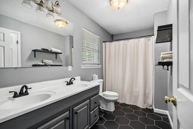 bathroom with tile patterned floors, vanity, a textured ceiling, toilet, and curtained shower