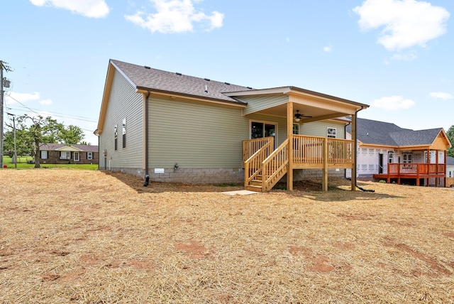 rear view of house with a wooden deck and ceiling fan