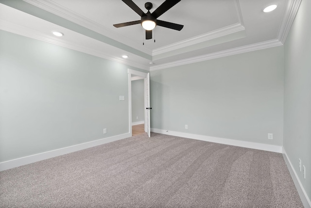 carpeted empty room featuring a tray ceiling, ceiling fan, and ornamental molding