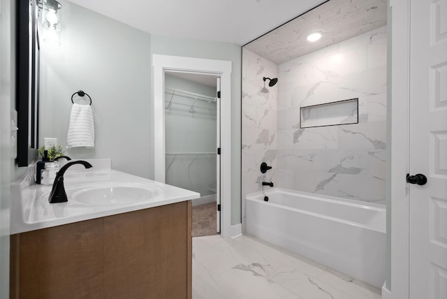 bathroom with tiled shower / bath combo and vanity