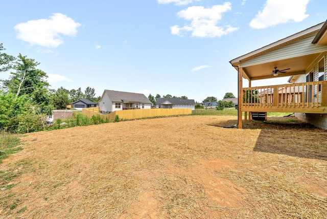 view of yard with a wooden deck and ceiling fan