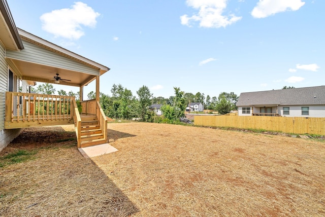 view of yard with a wooden deck and ceiling fan