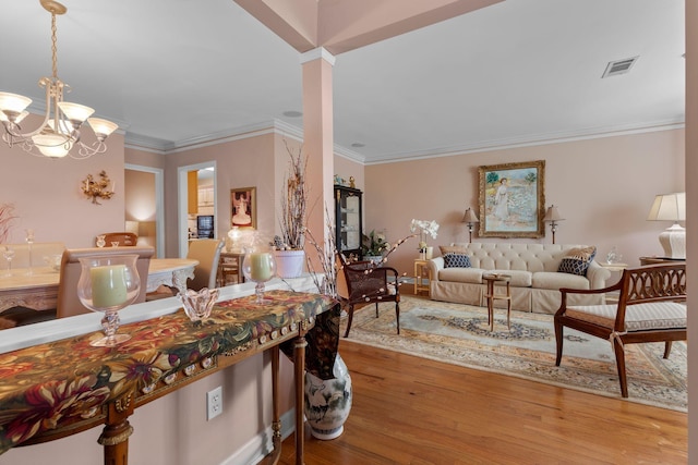 dining space featuring wood-type flooring, crown molding, and a chandelier