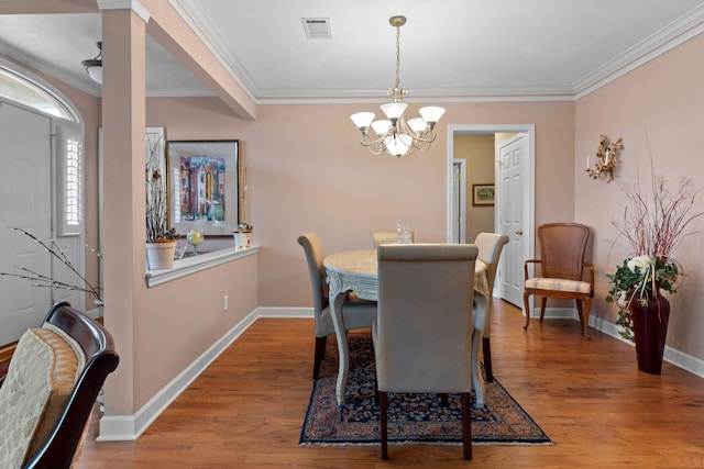 dining room featuring a chandelier, ornamental molding, and light hardwood / wood-style flooring