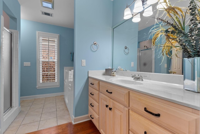 bathroom with tile patterned floors, vanity, and a shower with shower door