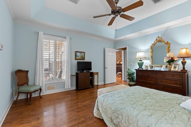 bedroom with dark hardwood / wood-style flooring, a tray ceiling, and ceiling fan