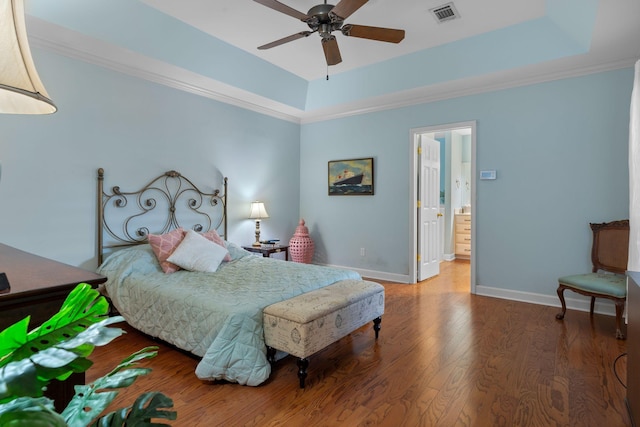 bedroom with a tray ceiling, ceiling fan, and wood-type flooring