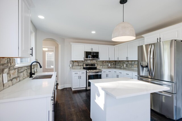 kitchen featuring sink, decorative light fixtures, white cabinets, and appliances with stainless steel finishes