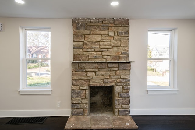 interior details featuring wood-type flooring and a stone fireplace