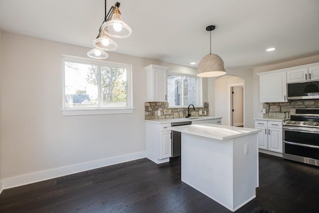 kitchen featuring white cabinetry, appliances with stainless steel finishes, and hanging light fixtures