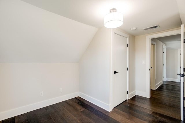 additional living space featuring dark hardwood / wood-style flooring and lofted ceiling