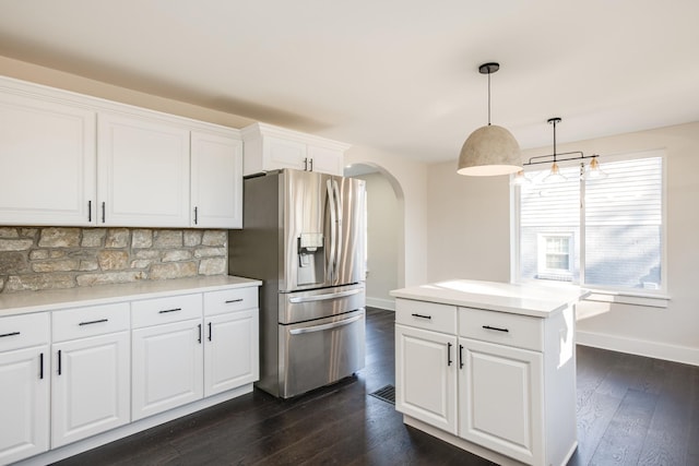 kitchen featuring pendant lighting, a center island, stainless steel refrigerator with ice dispenser, white cabinets, and dark hardwood / wood-style flooring