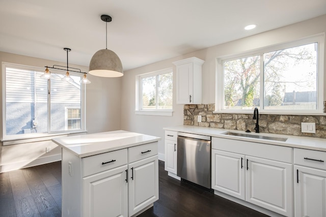 kitchen featuring pendant lighting, tasteful backsplash, sink, white cabinets, and stainless steel dishwasher