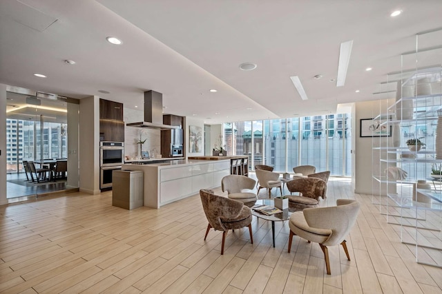 dining area with plenty of natural light, floor to ceiling windows, and light hardwood / wood-style floors