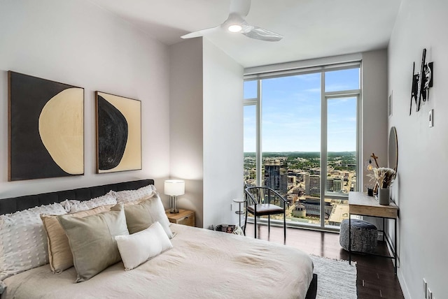 bedroom featuring ceiling fan, expansive windows, and wood-type flooring