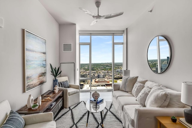 living room with ceiling fan and a wall of windows