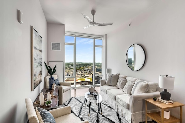 living room featuring ceiling fan and expansive windows