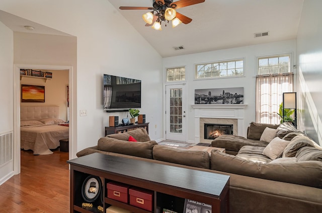 living room with ceiling fan, wood-type flooring, and high vaulted ceiling