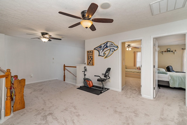 workout room featuring light carpet, a textured ceiling, and ceiling fan