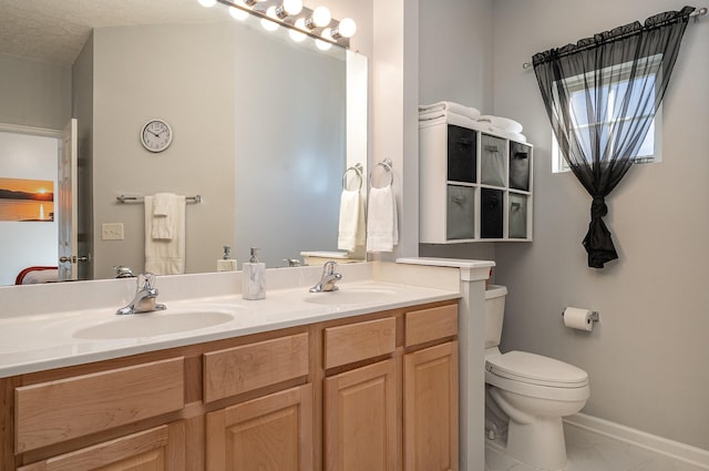 bathroom with tile patterned flooring, vanity, toilet, and a textured ceiling