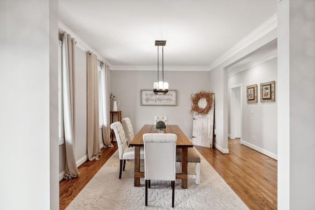 dining area with ornamental molding and light wood-type flooring