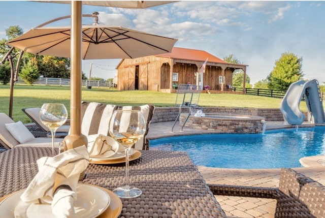 view of pool featuring a yard, an in ground hot tub, and a water slide