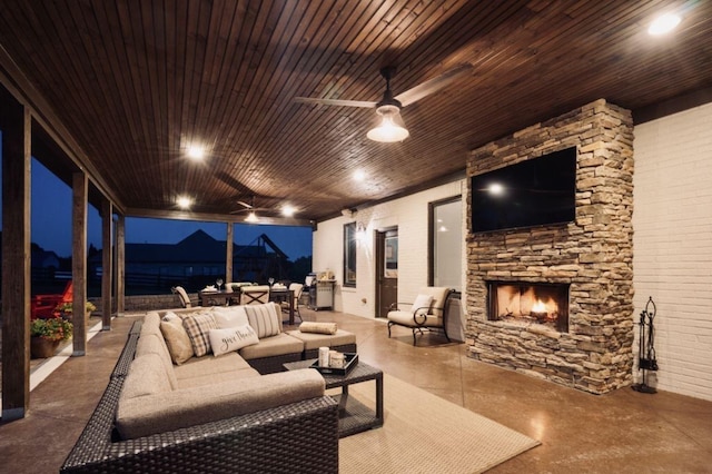 view of patio / terrace featuring an outdoor stone fireplace and ceiling fan