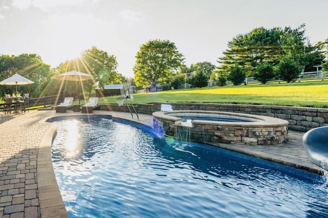 view of swimming pool featuring pool water feature, a yard, an in ground hot tub, and a patio