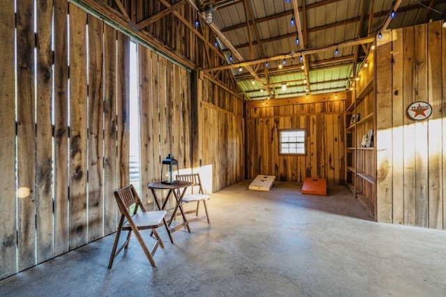 miscellaneous room featuring beamed ceiling and concrete floors