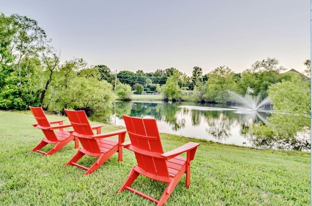 exterior space featuring a lawn and a water view