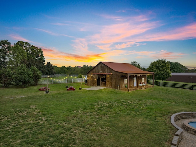 yard at dusk with a rural view and an outbuilding