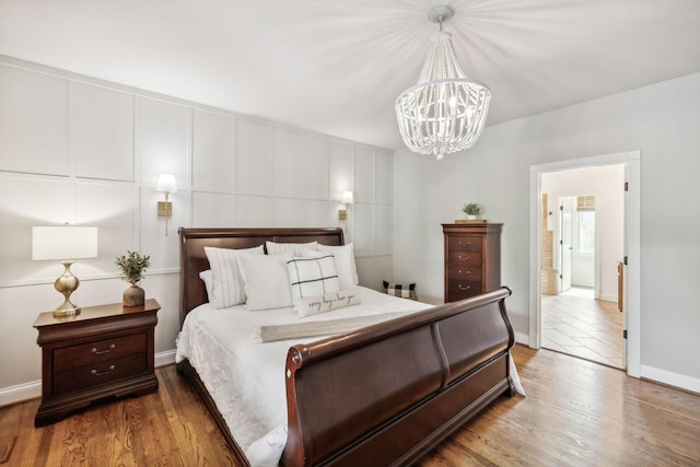 bedroom with hardwood / wood-style floors and a notable chandelier