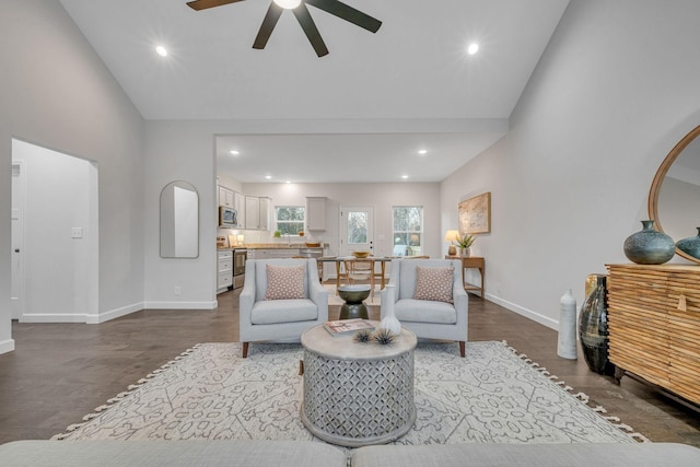 living room with ceiling fan, hardwood / wood-style floors, and a high ceiling