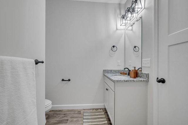 bathroom with vanity, hardwood / wood-style flooring, and toilet