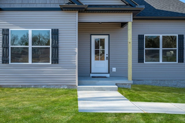 view of exterior entry featuring a lawn