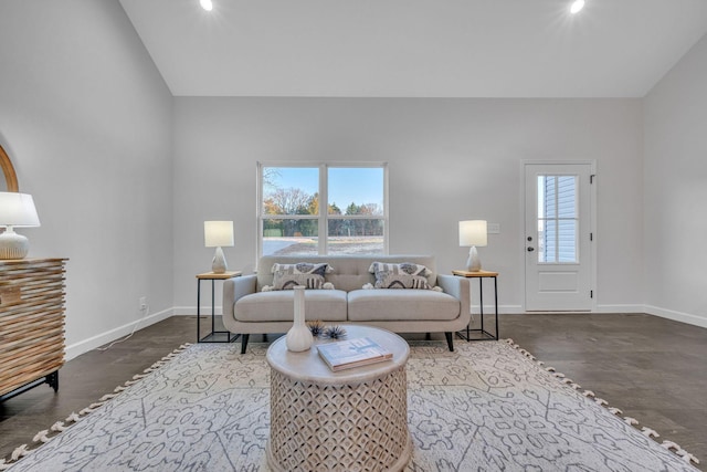 living room featuring a wealth of natural light, lofted ceiling, and hardwood / wood-style flooring