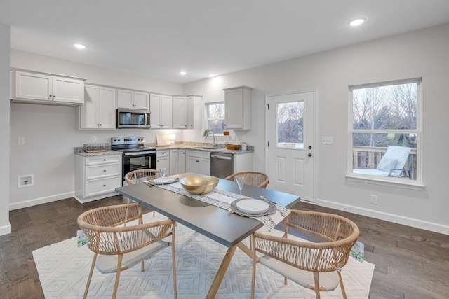 kitchen with white cabinets, sink, stainless steel appliances, and dark wood-type flooring