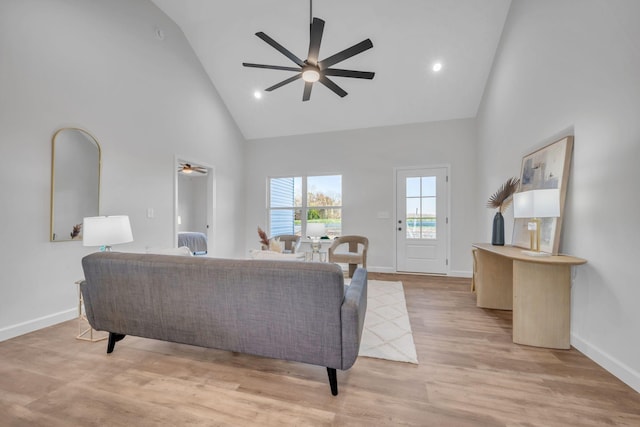 living room with ceiling fan, high vaulted ceiling, and light hardwood / wood-style floors