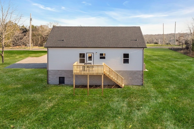 rear view of house featuring a yard and a wooden deck