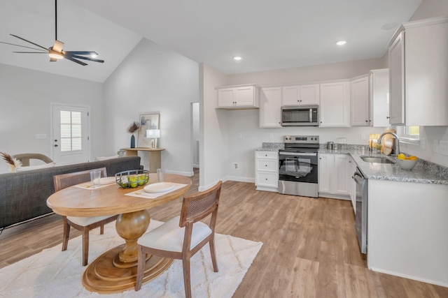 kitchen with light stone counters, white cabinetry, sink, and appliances with stainless steel finishes