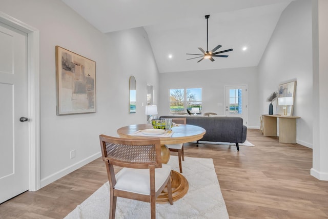 dining area with light hardwood / wood-style floors, high vaulted ceiling, and ceiling fan