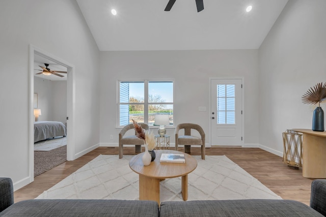 sitting room featuring ceiling fan, high vaulted ceiling, and light wood-type flooring